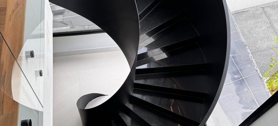 Escada metálica helicoidal com design exclusivo em ambiente sofisticado - a arte em aço da HBFER Estruturas Metálicas