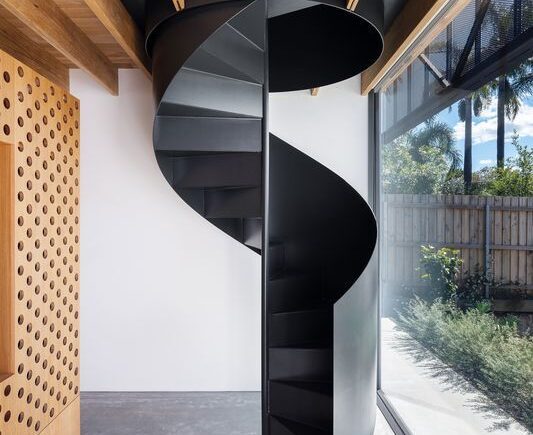 Escada metálica helicoidal com design exclusivo em ambiente sofisticado - a arte em aço da HBFER Estruturas Metálicas